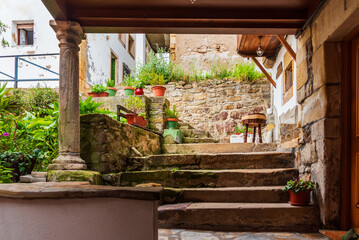 Fototapeta na wymiar Stone stairs under an arcade on a street in Lastres, Asturias.