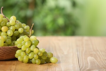 Delicious fresh green grapes on wooden table, closeup. Space for text