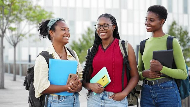 Group of African American female Students girls looking at camera smiling outdoors in the University campus