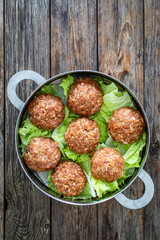 Lion's head meatballs - uncooked big meatballs with vegetables in stem pot on wooden background 