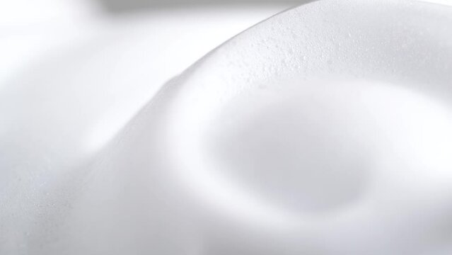 Hair foam mousse, macro. Beauty background. Close up of white cloud of hair mousse or shaving foam. Soap suds