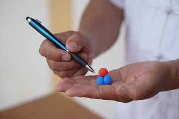 Closeup man hold pen , DIY molecule structure made from plasticine for teaching. Concept, teaching aids, educational materials. science education activity, creative DIY craft   