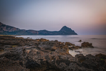 Italy,Sicily,Trapani district,San Vito Lo Capo,Mediterranean sea, Tyrrhenian sea,Gulf of Macari Makari illuminated in red in the early evening lights. June 2023