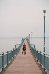 pier on the beach with a cyclist 