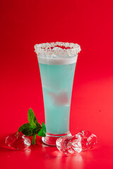 blue cocktail with coconut shavings on a bright background