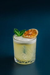 Refreshing yellow cocktail with mint and citrus on a bright background