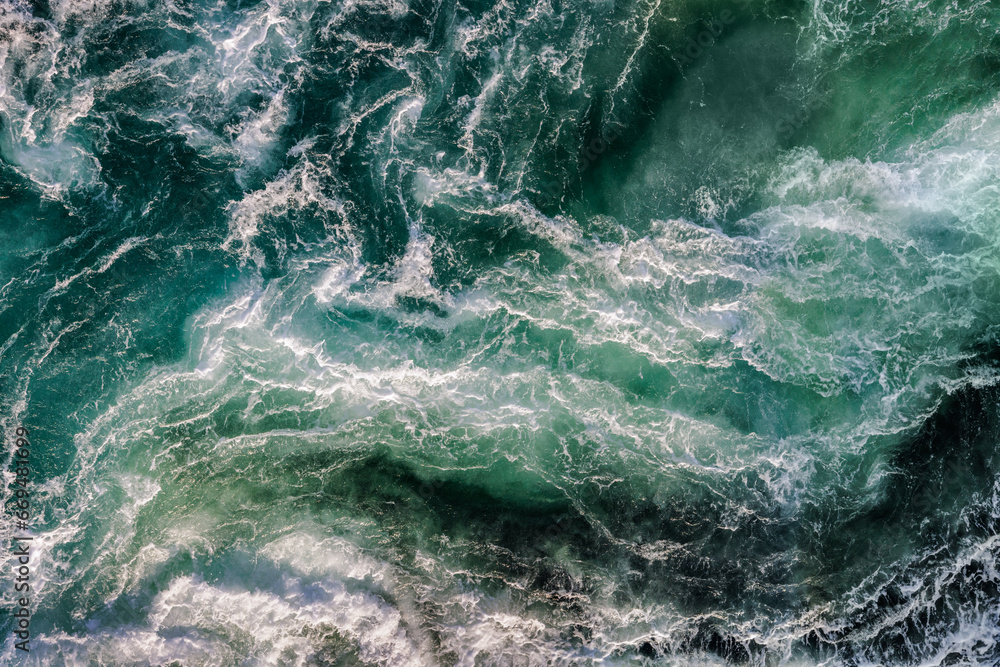 Wall mural blue waves of water of the river and the sea meet each other during high tide and low tide.