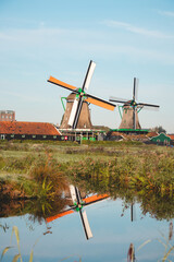 Fototapeta premium Popular tourist spot Zaanse Schans is near Amsterdam in the west of the Netherlands. Historical, realistic windmills during sunrise. Holland's landmark