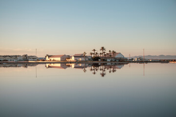 Fototapeta na wymiar Reflection in the calm water of the salt complex of the Salinas Regional Park of San Pedro del Pinatar, Region of Murcia, Spain