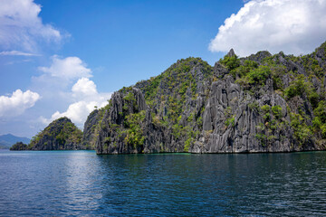 Naklejka premium Majestic limestone formations towering over serene blue waters