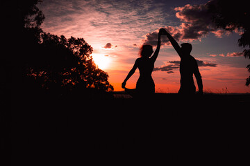 Couple dancing salsa at sunset,silhouette of couple in love at sunset against the backdrop of...