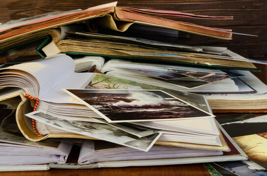 Stack of photo albums and scattered photographs