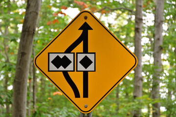 Caution yellow safety sign. Choose your way between expert and extreme. Black diamond versus double black diamond. Mountain bike trail rating sign. Concept of all roads lead to Rome.