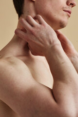 Minimal detail shot of young man scratching neck in frustration