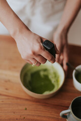 woman stirring a bowl with matcha