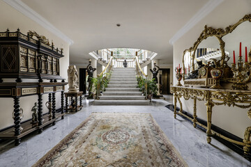 Hallway of a multi-story luxury single-family home with white marble staircase railings, floors of...
