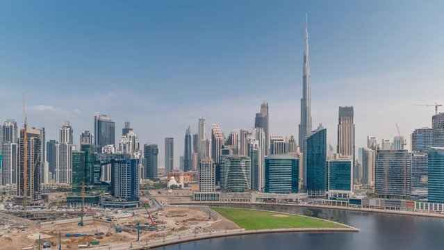 Aerial panoramic view to Dubai Business Bay and Downtown with the various skyscrapers and towers along waterfront on canal timelapse. Construction site with cranes