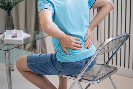 Back pain, kidney inflammation, man suffering from backache at home