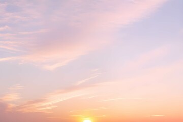 Obraz premium 淡いピンクとオレンジの夕焼け空に白いふわふわの雲と沈む太陽、夕暮れ時の空の色彩と雲の形の変化