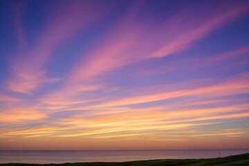 夕日に染まる空とシルエットの丘と静かな湖、オレンジとピンクの空が広がる風景
