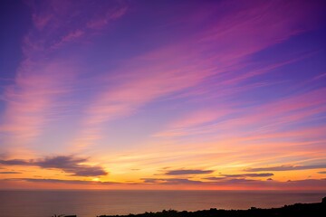 Obraz premium 夕日に染まる空とシルエットの丘と静かな湖、オレンジとピンクの空が広がる風景