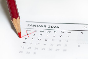 A red pen marks the first of January on a 2024 calendar. The background is white.