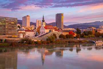 Linz, Austria. Cityscape image of riverside Linz, Austria at beautiful autumn sunrise with reflection of the city in Danube River.