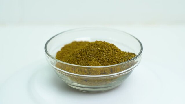 A transparent plate with a mixture of seasonings rotates on the turntable. Close-up. View from above