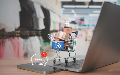 Sale percentage with shopping cart and boxes placed on computer keyboard. Online shopping concept,...