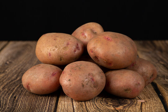 Red potatoes on a dark background. Sale of fresh potatoes.