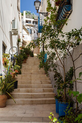 Blue and white houses in typical street in Barrio Santa Cruz in Alicante, Costa Blanca, Spain