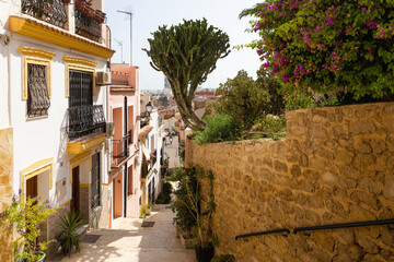 Narrow street with stairs in Barrio Santa Cruz in Alicante, Costa Blanca, Spain.