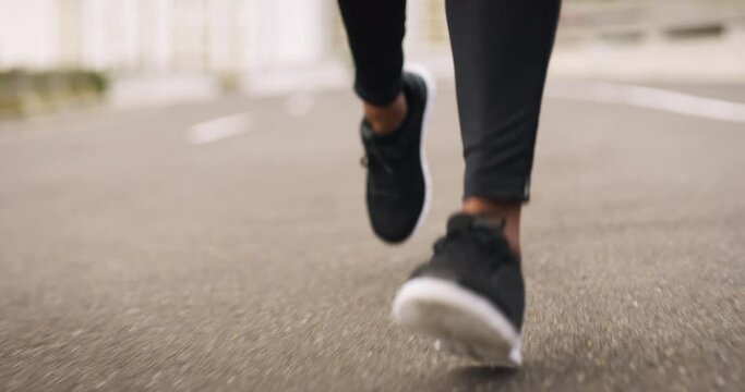Feet, fitness and a person running on the road closeup during a marathon, race or cardio training. Exercise, shoes and a sports athlete on the street for a workout to improve health or performance