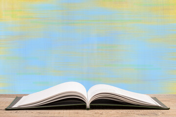 Composition with hardback books, fanned pages on wooden deck table and blue background. Books stacking. Back to school. Copy Space. Education background.