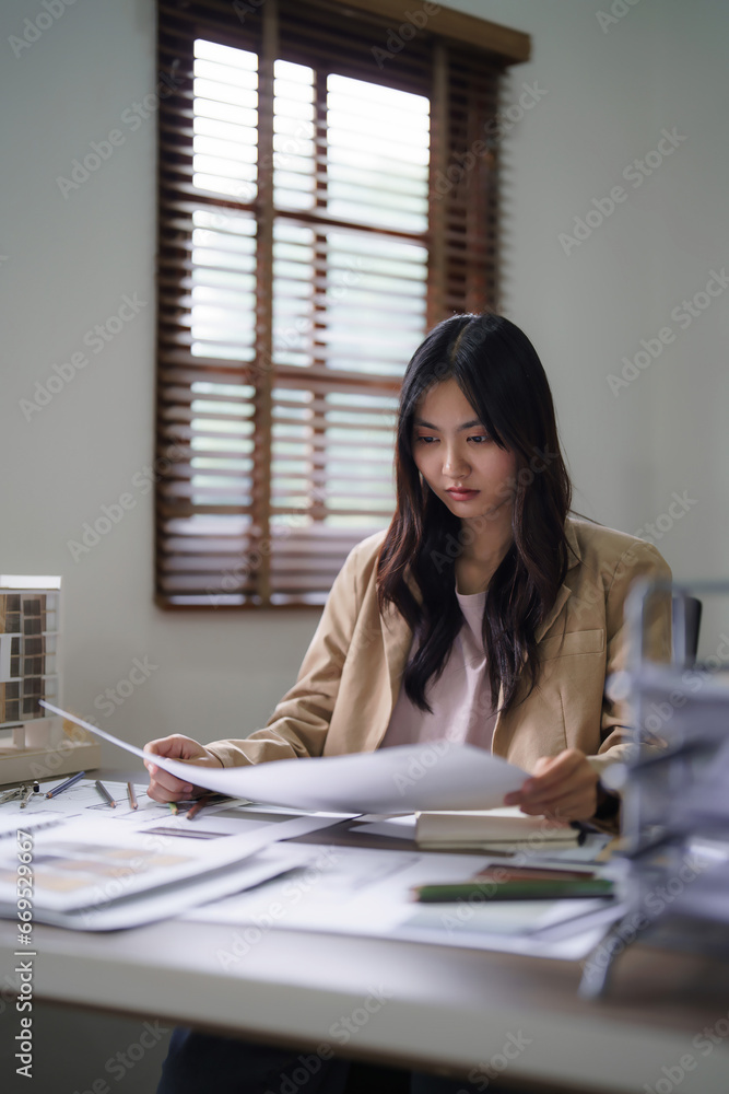 Poster female architect checking sketch of interior building project and color swatch sample on blueprint