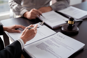 Businessman explaining about detail of business to lawyer and taking notes in document while male attorney are consultation about legislation agreement and terms data of business contract in law firm