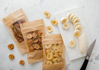 Various crunchy and chewy banana slices with peeled banana on light board.Top view.