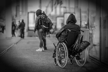 Ein Obdachloser im Rollstuhl vor einem öffentlichen Gebäude