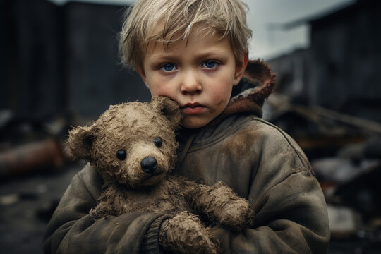 Portrait of sad homeless child on the city streets holding teddy bear