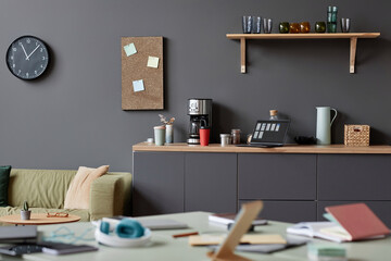 Background image of lived in cluttered office space in neutral grey with focus on coffee station,...