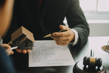 Justice and Law concept. Legal counsel presents to the client a signed contract with gavel and...