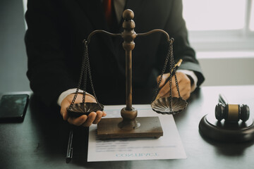 Justice and Law concept. Legal counsel presents to the client a signed contract with gavel and...