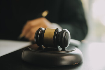 Justice and Law concept. Legal counsel presents to the client a signed contract with gavel and...