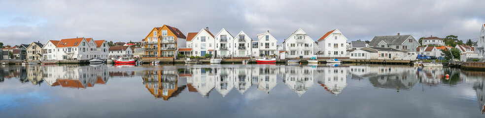 Houses and boats are reflected in the water