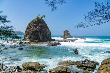 Rocky shoreline of Watu Lumbung Beach, Indonesia. Tidal waves hits the coral rock