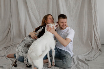 Fototapeta premium Couple with dogs having fun at home, light photo