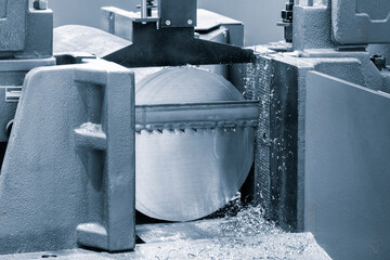 The automatic band saw machine cutting the metal bar with coolant method. The machine tool for industrial purpose.