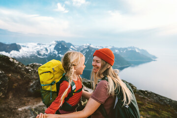 Mother hiking with daughter family together travel outdoor active vacations in mountains of Norway parent and kid girl with backpack happy moments - 669561868