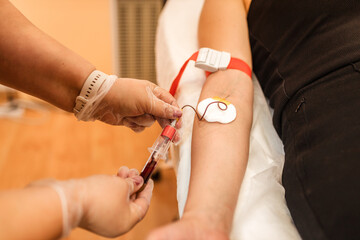 A nurse takes a blood sample from a girl's vein.