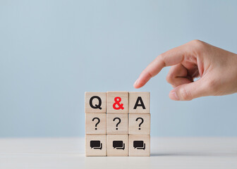 Question and answer concept. Q and A symbols on wooden blocks and hand selected Frequently asked...